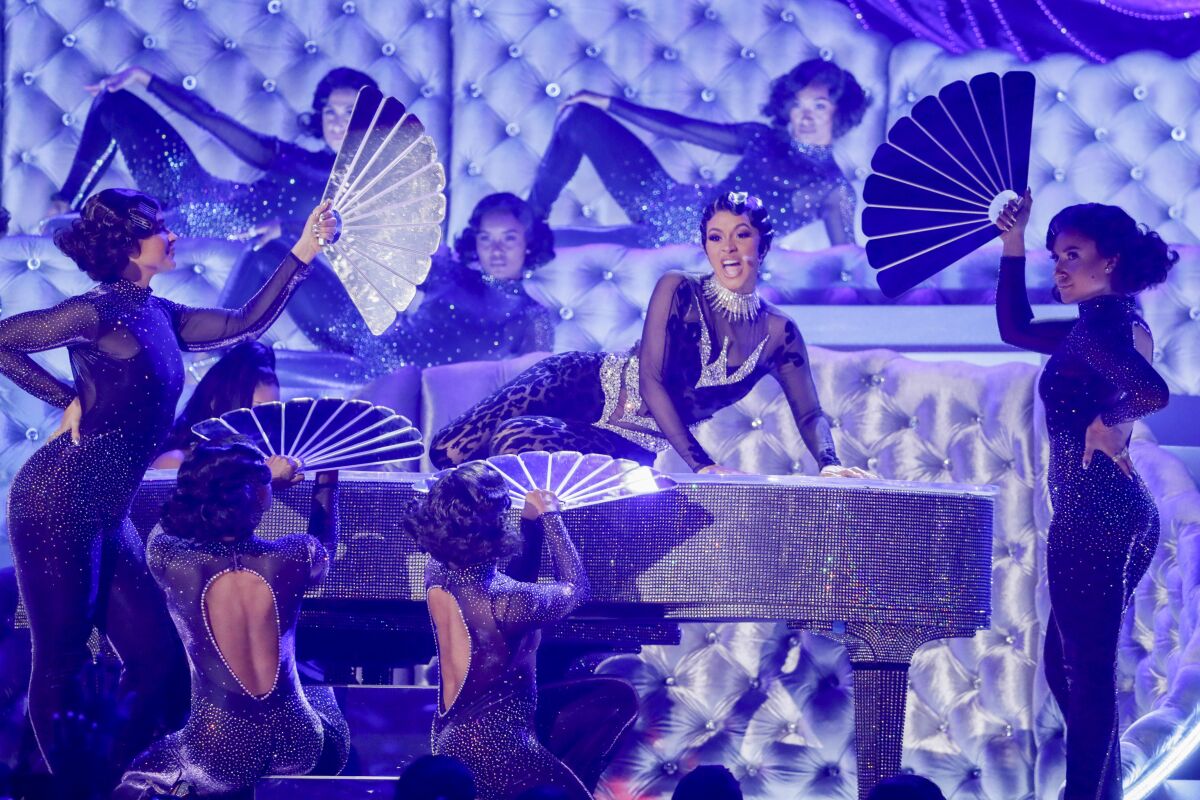 Cardi B performs at the 61st Grammy Awards, on top of a piano and surrounded by dancers.