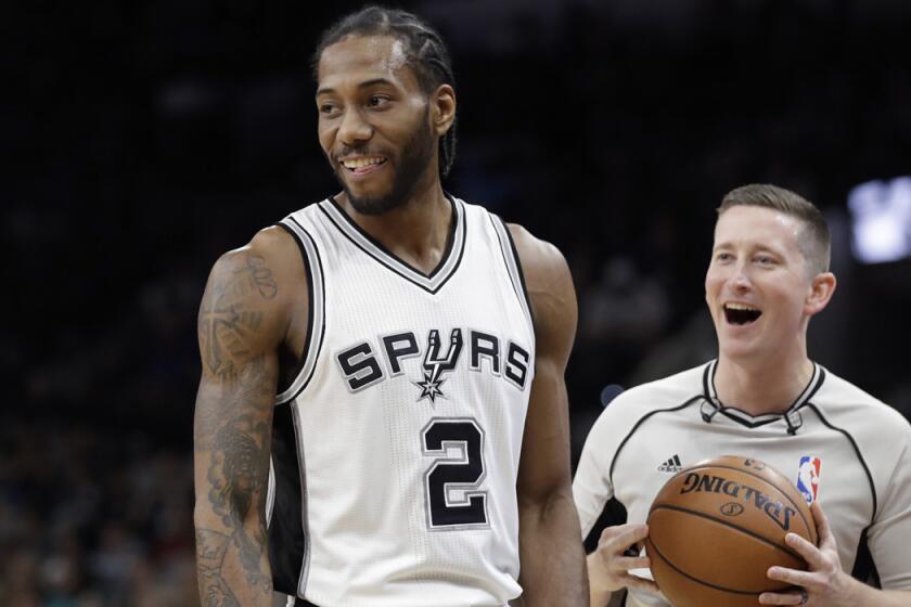 San Antonio Spurs forward Kawhi Leonard (2) and referee Nick Buchert (3) share a laugh during the first half of a game against the Toronto Raptors on Tuesday.