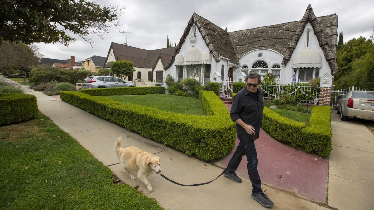 Erich Anderson, who has lived in the Carthay Circle neighborhood since 1997, walks his dog, Becky. He and other neighbors fear that Senate Bill 50 being debated by California lawmakers would increase housing density.