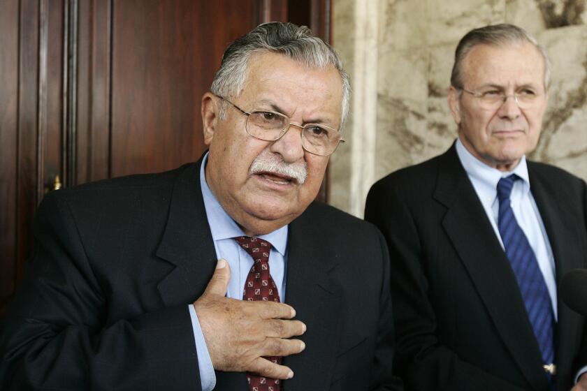 Former Iraqi President Jalal Talabani, left, and then-U.S. Secretary of Defense Donald Rumsfeld talk at a press conference in Baghdad, Iraq on April 12, 2005.