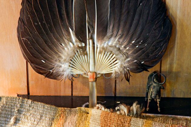 In the living room alcove, a feather fan with wrapped handle and another Nandi figurine from India.