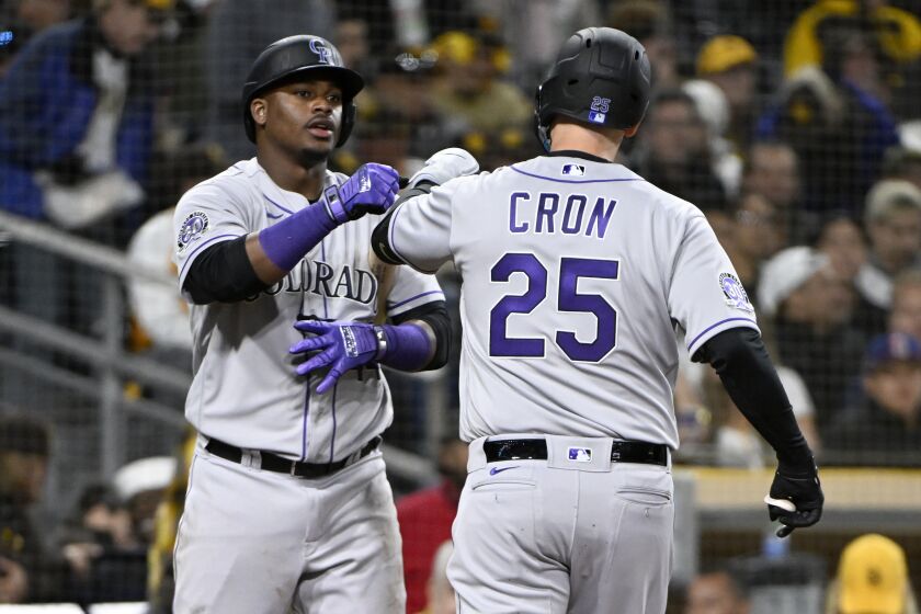 Colorado Rockies' C.J. Cron, right, gets congratulations from Elehuris Montero after hitting a solo home run, Cron's second of the baseball game, against the San Diego Padres during the seventh inning in San Diego, Thursday, March 30, 2023. (AP Photo/Alex Gallardo)