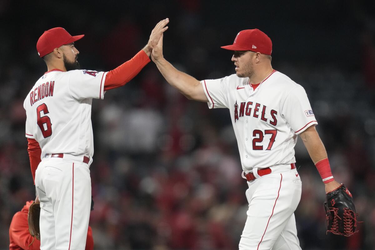 Angels third baseman Anthony Rendon and center fielder Mike Trout celebrate after a 5-3 win over the Oakland Athletics.
