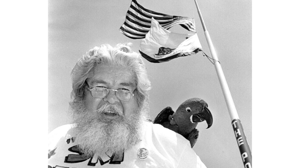 1989 photo of Thomas 'Ski' Demski with his parrot'Peppy' in front of his flagpole in Long Beach.