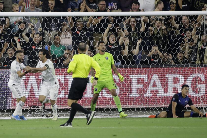 LAFC forward Carlos Vela, second from left, celebrates with teammate Diego Rossi, left, after scoring past San Jose goalkeeper Daniel Vega and defender Nick Lima on Wednesday night at Banc of California Stadium.