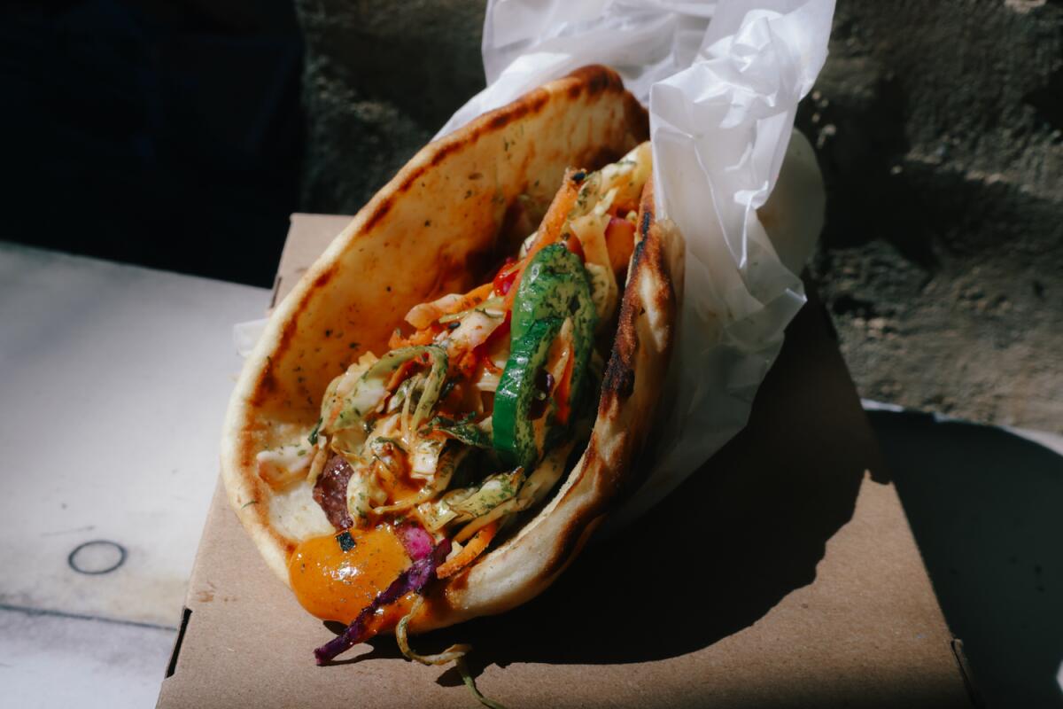 Anaheim, CA - March 02: The Ronto-less Garden Wrap is made with plant-based sausage, spicy kimchi slaw, sweet pickled cucumber, gochilijang spread and wrapped in a pita and is seen at Ronto's Wrap at Disneyland Park on Thursday, March 2, 2023 in Anaheim, CA.(Dania Maxwell / Los Angeles Times).