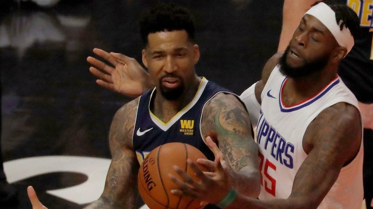 Clippers center Willie Reed, right, defends against Nuggets forward Wilson Chandler in the first quarter on Wednesday at Staples Center.