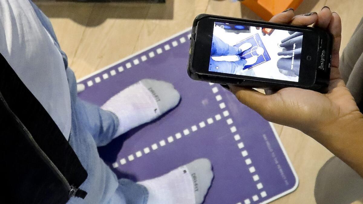 Nike officials demonstrate the company's foot-scanning app.
