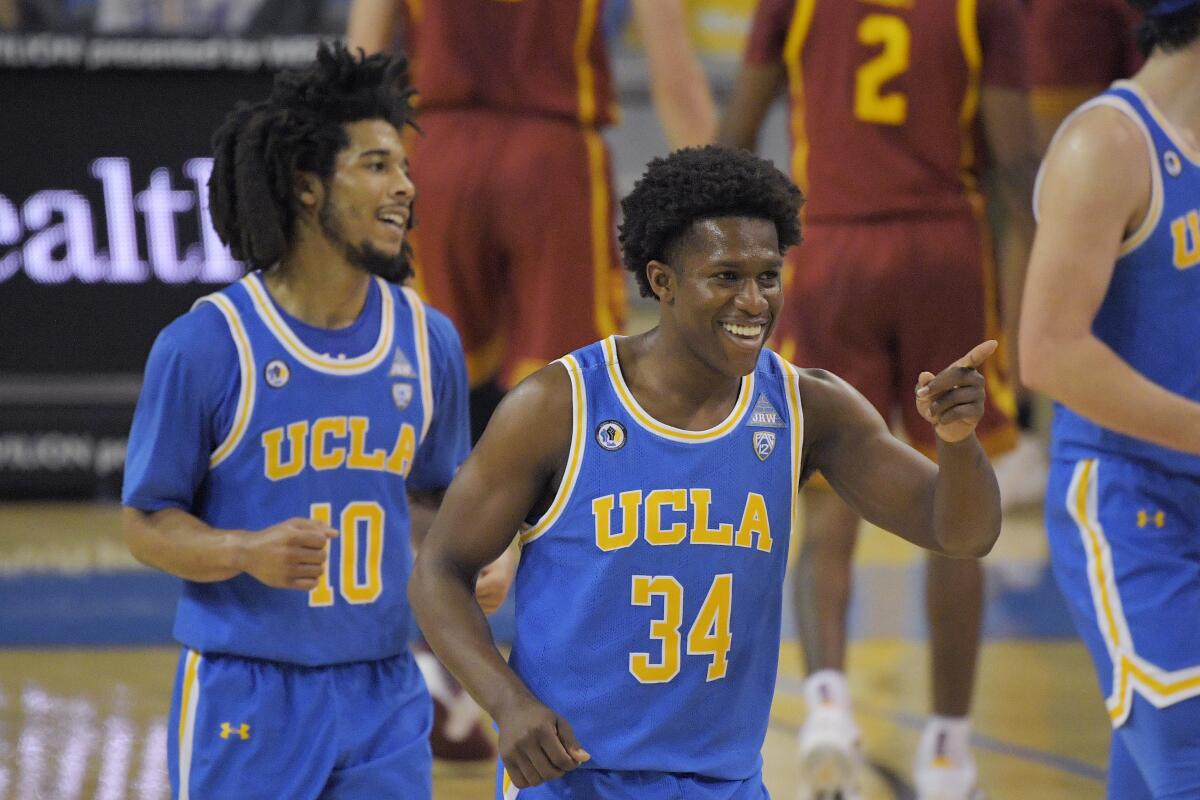 UCLA guard David Singleton celebrates along with guard Tyger Campbell during a loss to USC