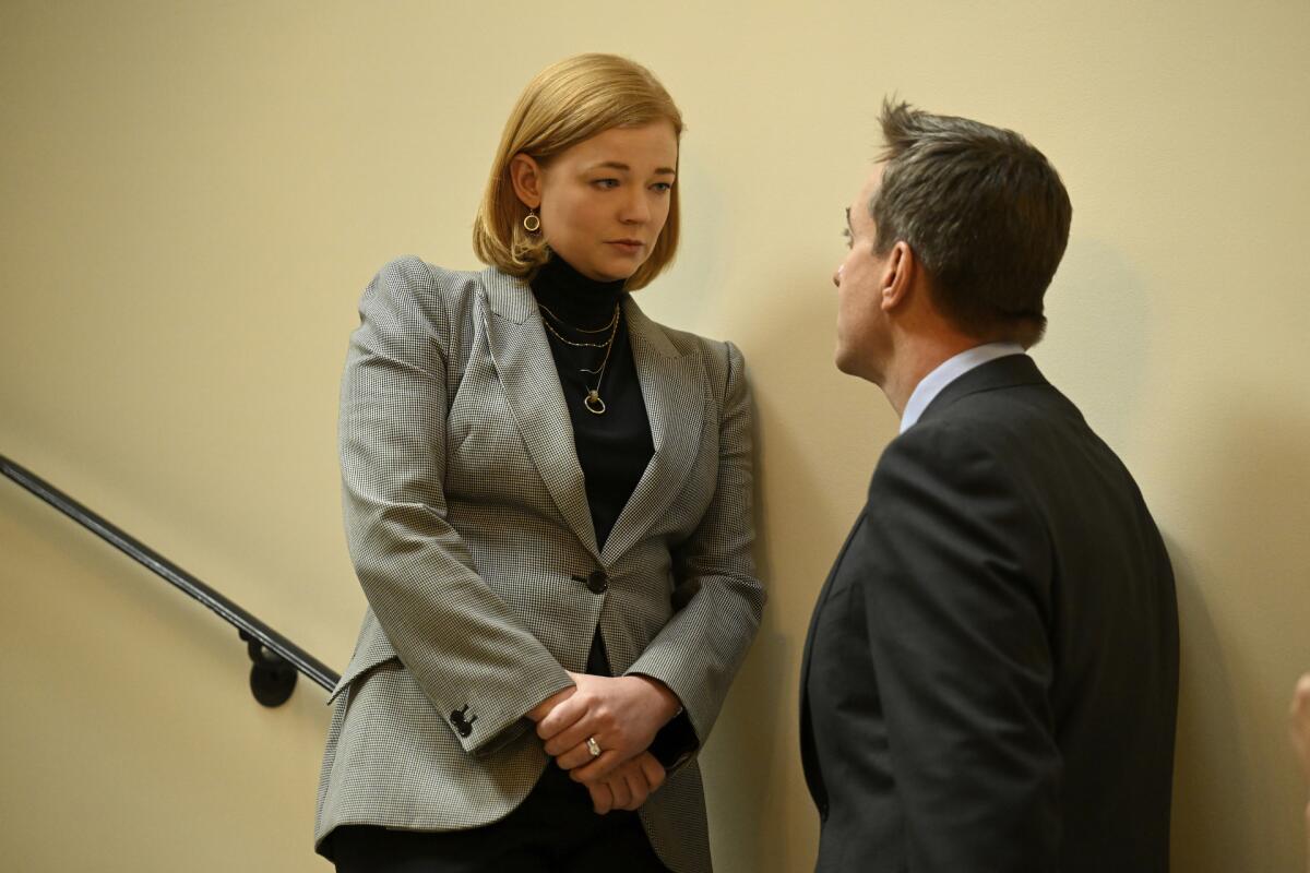 A woman (Sarah Snook) on a higher step talks seriously with a man (Matthew Macfadyen) in a stairwell in "Succession."