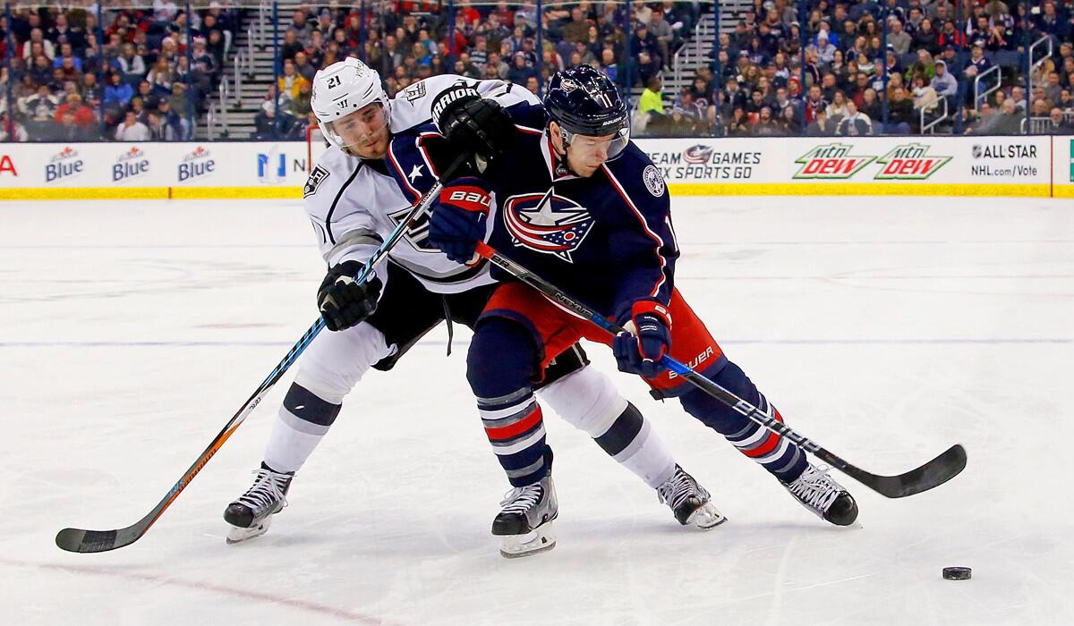 Columbus Blue Jackets' Matt Calvert (11) and Kings' Nick Shore (21) battle for control of the puck during the second period on Tuesday.
