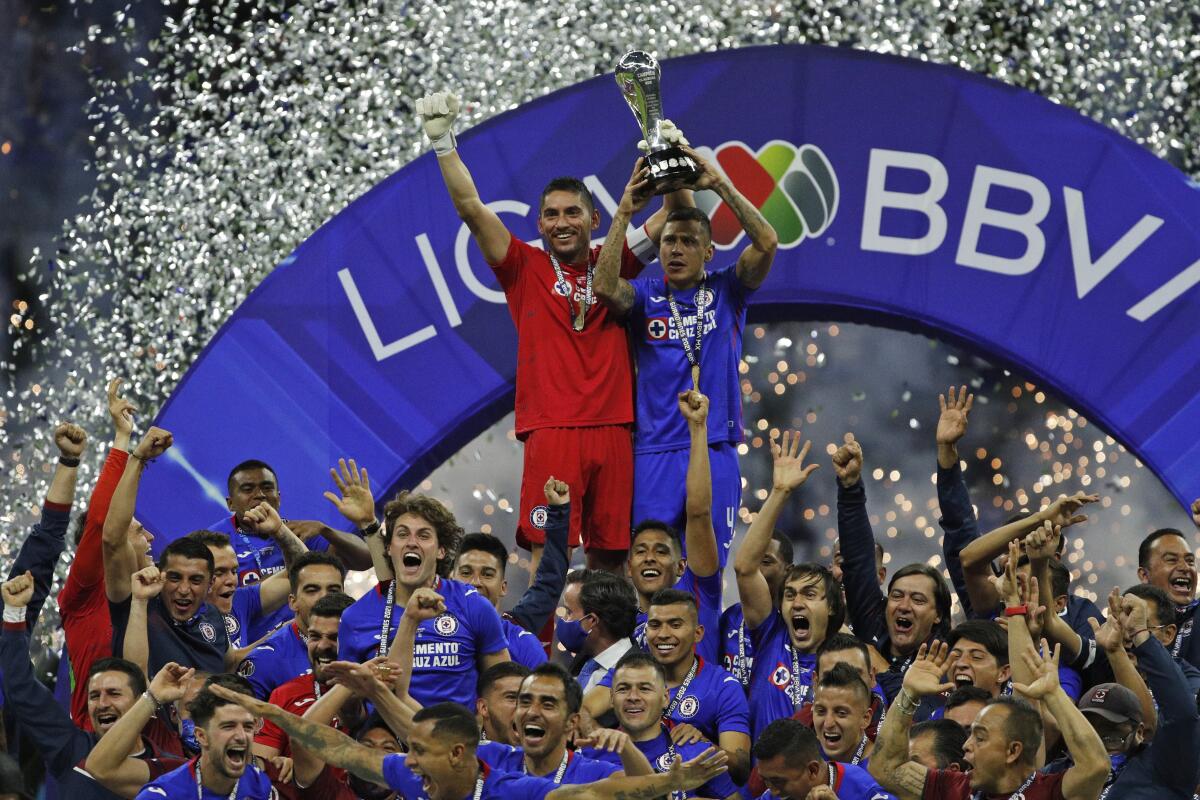 Cruz Azul's goalkeeper Jose Corona, left, and Julio Dominguez lift the trophy 