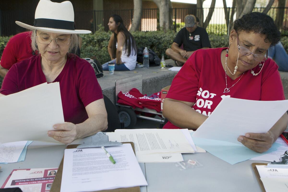 Cal State Los Angeles faculty lecturer Leone Hankey, left, and California Faculty Assn. representative Jackie Teepen gather signatures at Cal State L.A. to appeal for pay raises.