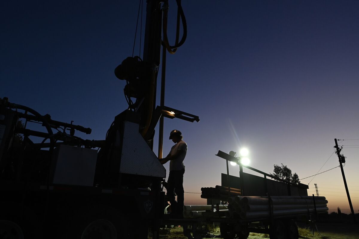 A drilling rig digs a well in darkness.