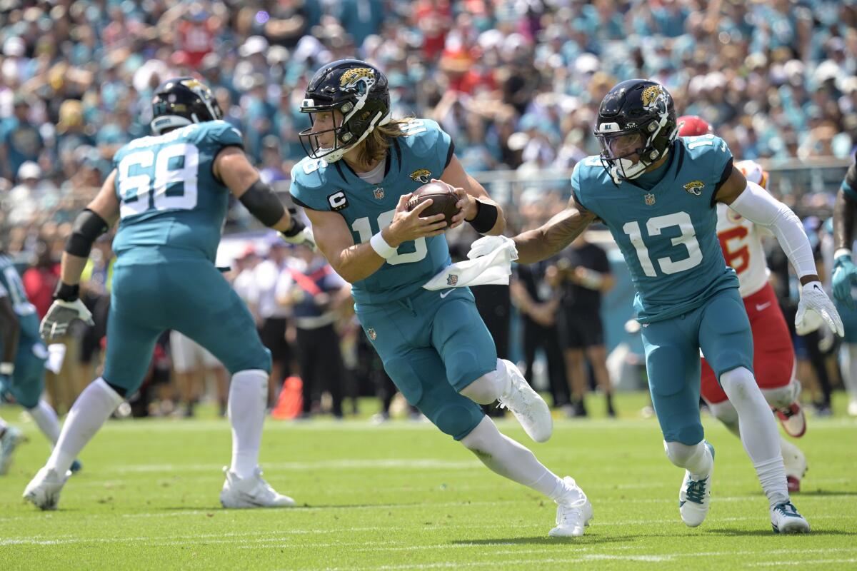 Jaguars quarterback Trevor Lawrence (16) looks for a receiver after recovering an errant snap against the Chiefs.