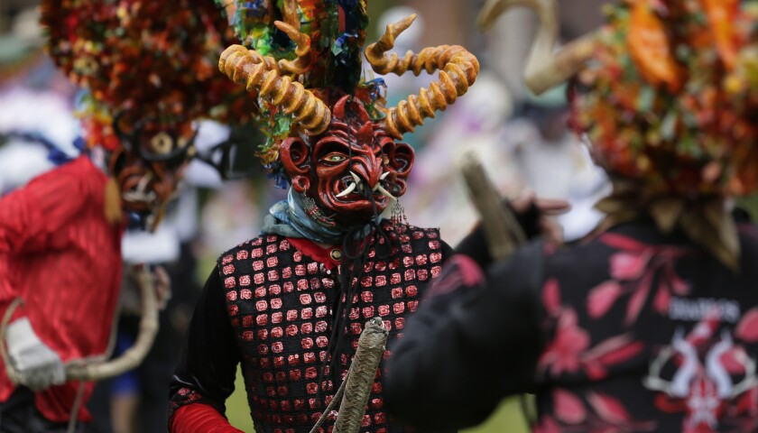 People dressed as devils dance in La Diablada Pillarena amid the COVID-19 pandemic in Pillaro, Ecuador, Wednesday, Jan. 6, 2021. Performers took to the streets of this small city in the center of the country with only 40 characters dancing in a closed place and without an audience. (AP Photo/Dolores Ochoa)