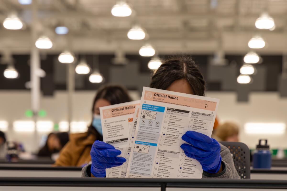 A worker holds paperwork, with other workers in the background