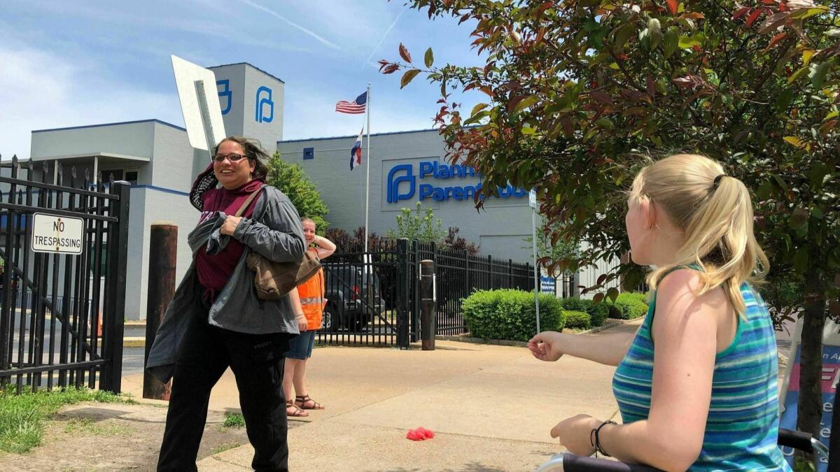 An abortion opponent, right, speaks to a passerby during a protest outside a Planned Parenthood clinic in St. Louis on May 17, the day the Missouri Legislature passed a measure banning the procedure at eight weeks of pregnancy.