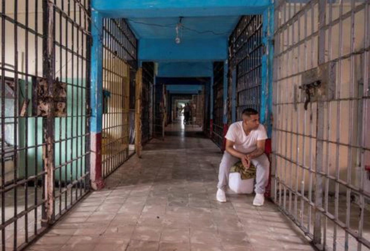 Un hombre se sienta este sábado en un pasillo entre las celdas del penal 