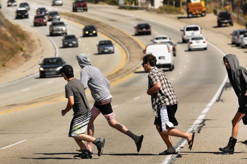 Pedestrians run to cross Pacific Coast Highway in Malibu as vehicles speed past in April. As of June, four people had died in 117 accidents in 2015 along the Malibu portion of PCH, according to the Los Angeles County Sheriff’s Department.