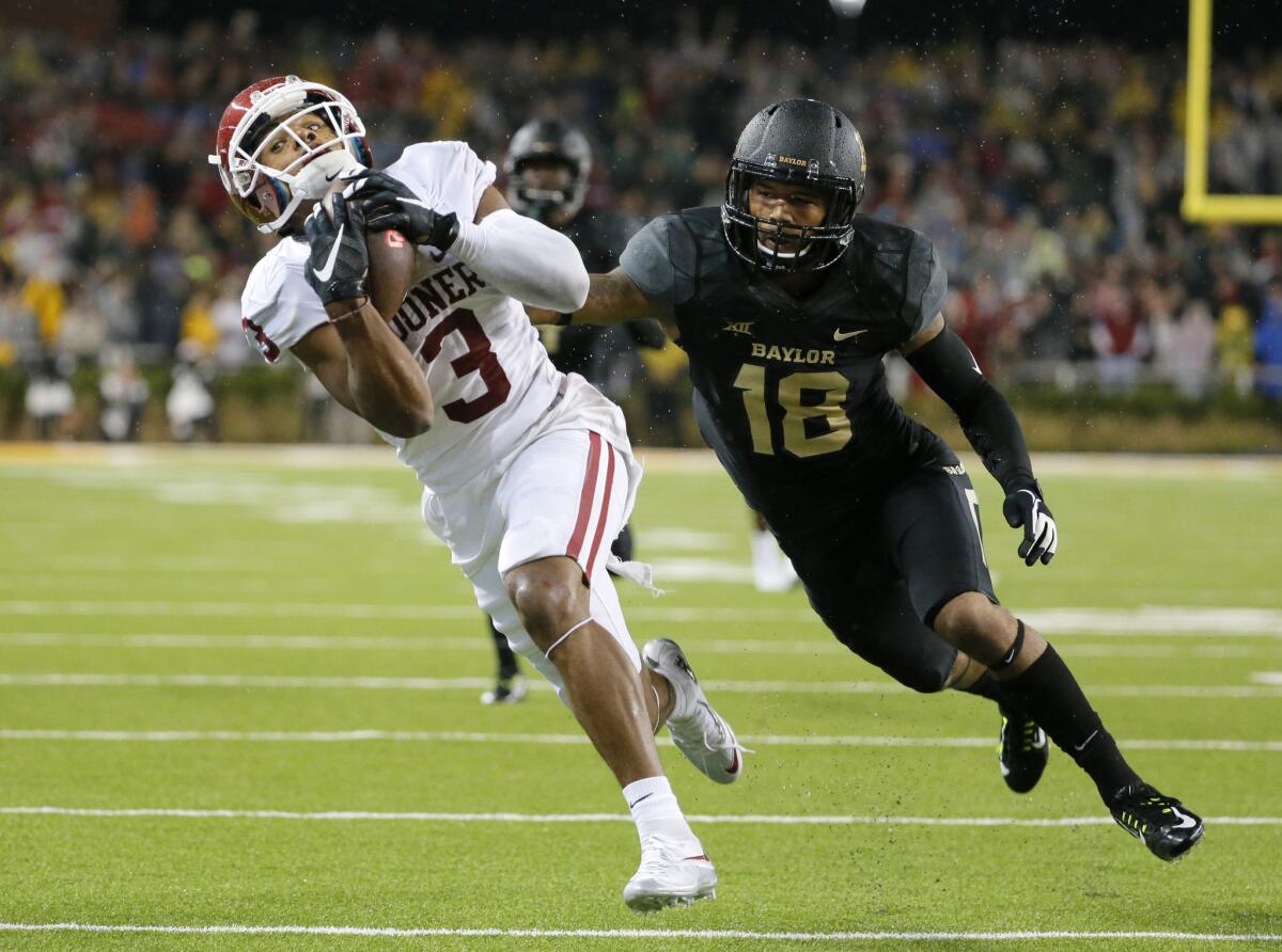 Oklahoma's Sterling Shepard catches a long pass before scoring a touchdown as Baylor's Chance Waz defendson Saturday.