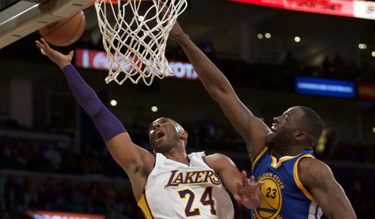 The Lakers' Kobe Bryant goes up for a shot against Golden State's Draymond Green on March 6.