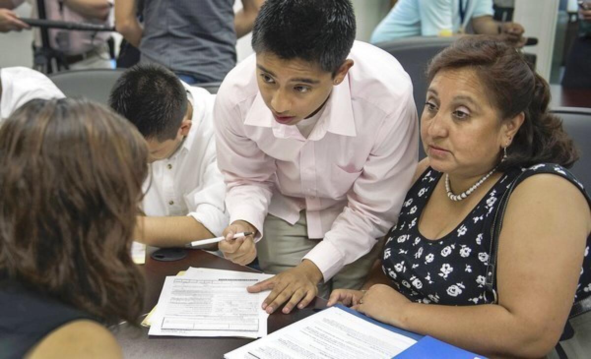 Applicants and relatives fill out paperwork in Washington for the Obama administration's work permit program. All applicants must prove they came to the U.S. before age 16 and have been here continuously for the last five years, among other requirements.