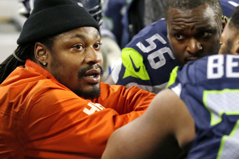 FILE - In this Dec. 4, 2016, file photo, retired Seattle Seahawks running back Marshawn Lynch, left, chats on the sidelines players on the bench in the second half of an NFL football game against the Carolina Panthers in Seattle. Lynch has visited the Oakland Raiders as he decides whether to come back to the NFL and the team decides whether it wants to acquire the hometown favorite. A person familiar with the visit says Lynch came to the facility on Wednesday, April 5, 2017, to meet with Raiders officials. The person spoke on condition of anonymity because the visit wasn't announced by the team. (AP Photo/Ted S. Warren, File)