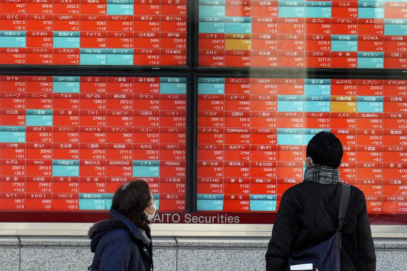 FILE - People look at an electronic stock board showing Japan's stock prices at a securities firm in Tokyo, on Jan. 17, 2024. Asian stocks were mixed Wednesday, Feb. 21, 2024 after technology stocks led Wall Street broadly lower on Tuesday, with investors waiting for chipmaker Nvidia's quarter earning report. (AP Photo/Eugene Hoshiko, File)