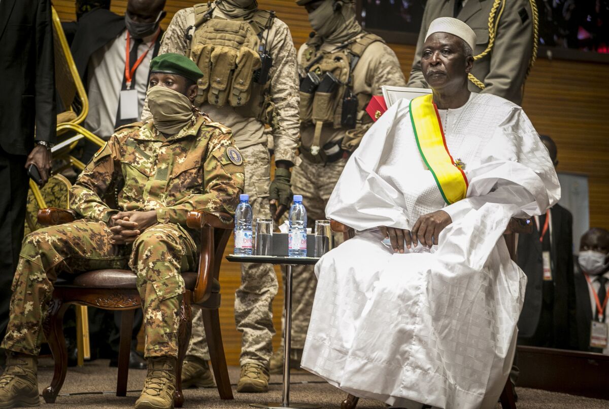 Mali's retired Col. Maj. Bah N'Daw, right, is sworn into the office of transitional president, and Col. Assimi Goita, left