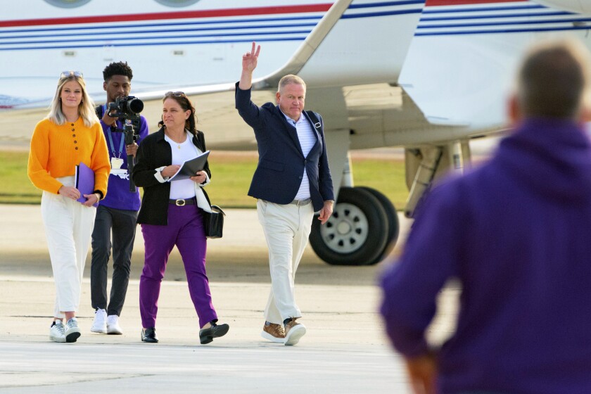 New LSU football coach Brian Kelly gestures to fans after his arrival at Baton Rouge Metropolitan Airport, Tuesday, Nov. 30, 2021, in Baton Rouge, La. Kelly, formerly of Notre Dame, is said to have agreed to a 10-year contract with LSU worth $95 million plus incentives. (AP Photo/Matthew Hinton)