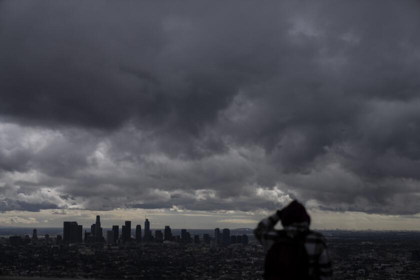 Storm clouds hover over Los Angeles, Thursday, Feb. 23, 2023. For the first time since 1989, the National Weather Service issued a blizzard warning for the Southern California mountains. (AP Photo/Jae C. Hong)