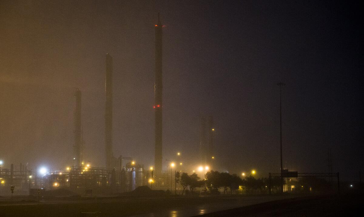 Una refinería ilumina la lluvia que deja el huracán Harvey a su paso por Corpus Christi, Texas.