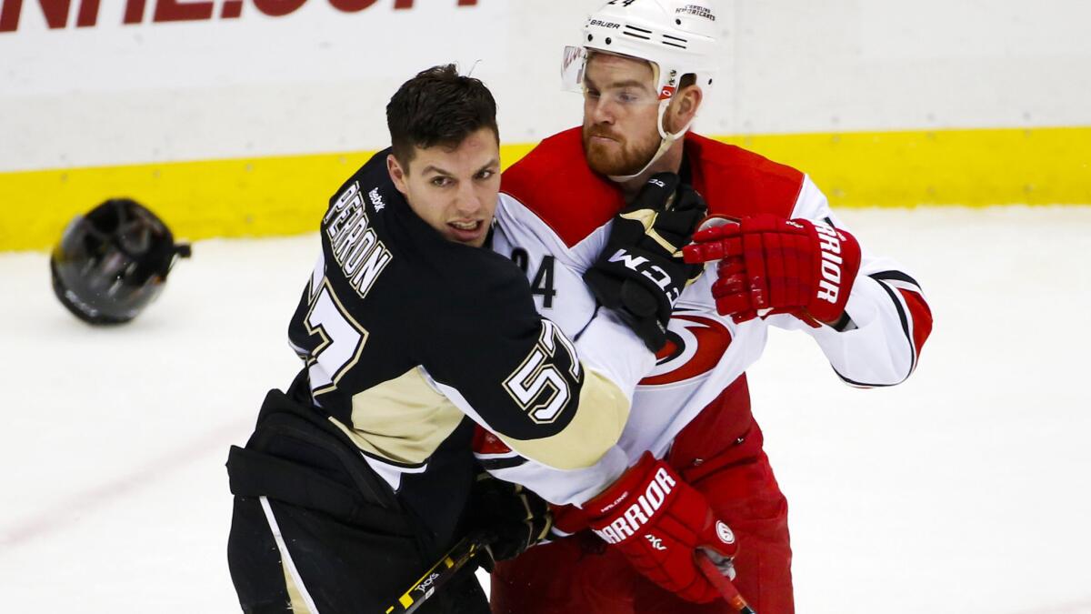 Penguins left wing David Perron (57) and Hurricanes center Brad Malone battle for position during a game earlier this season.