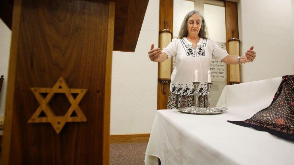 Keren Friedman lights candles before a celebration of the Sabbath at the Congregation B'Nai David synagogue in Visalia, Calif., on Friday, Nov. 2, 2018.