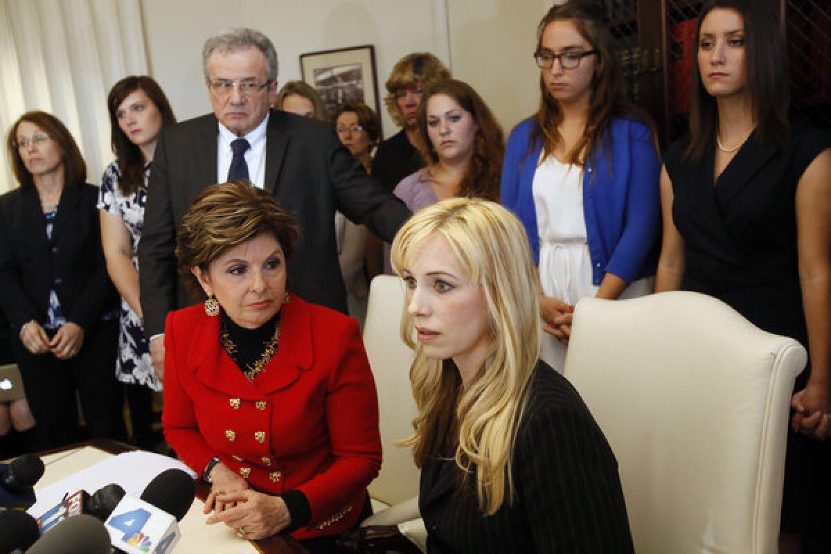 LOS ANGELES, CA - APRIL 18, 2013: Attorney Gloria Allred, left sitting and Dr. Caroline Heldman, professor of politics, along with 6 sexual assault victims at a news conference to announce the filing of a complaint against Occidental as a result of what the women allege is the college's "Deliberate indifference to rape victims."