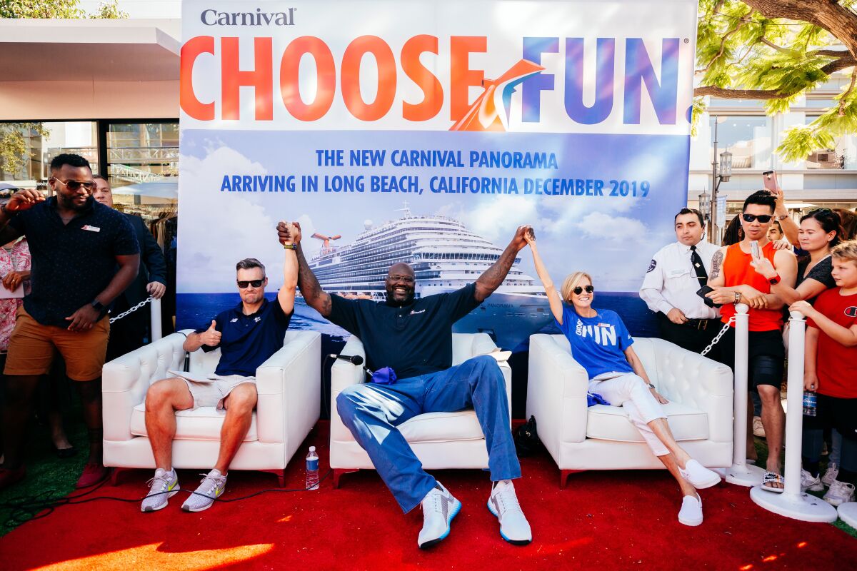 Shaquille O'Neal, center, has some fun during a Carnival Cruises event at the Grove in Los Angeles last year. After all, he's the cruise line's chief fun officer.