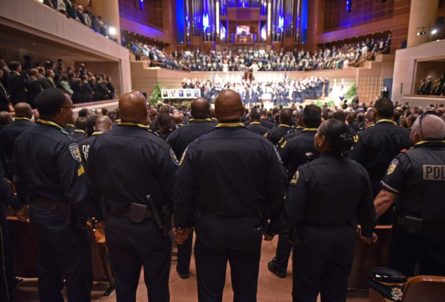 Police join hands during the singing of "The Battle Hymn of the Republic" during an interfaith memorial service for the victims of the Dallas police shooting at the Morton H. Meyerson Symphony Center on July 12, 2016 in Dallas, Texas.