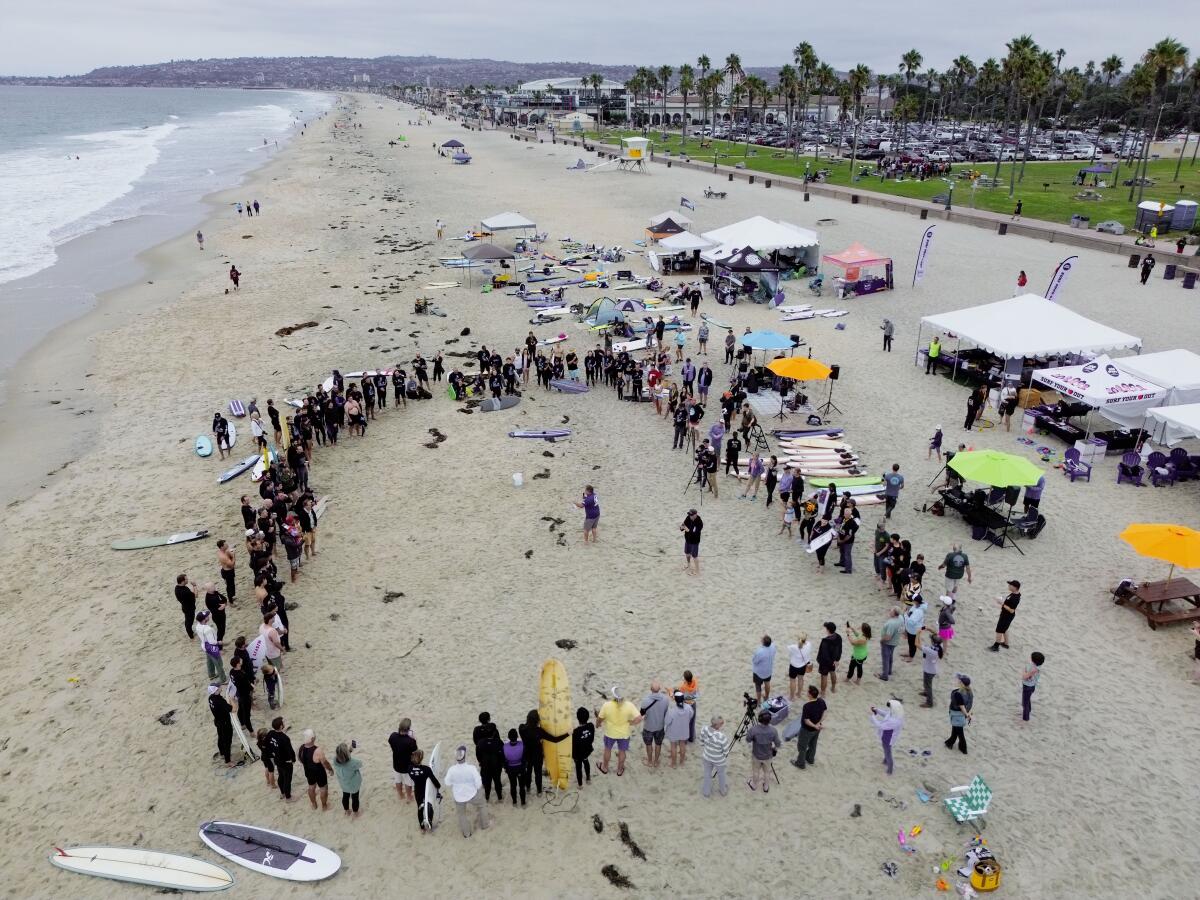 Participants for a tribute circle on the beach during the 14th Annual B2M Wave Challenge in Mission Beach.