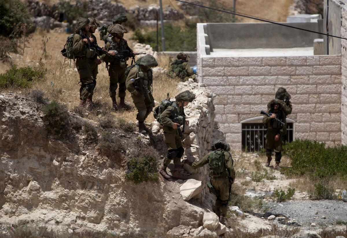 Israeli soldiers conduct a search for three missing teenagers outside the West Bank city of Hebron on Monday.