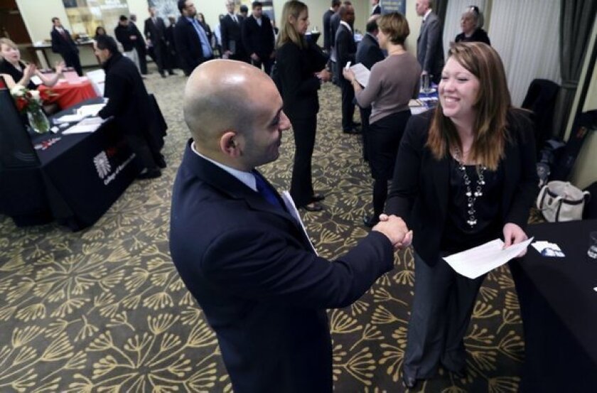 Sayed Mouawad of Providence, R.I., shakes hands with Jillian Wallace of Matix Inc. during a job fair in Boston.