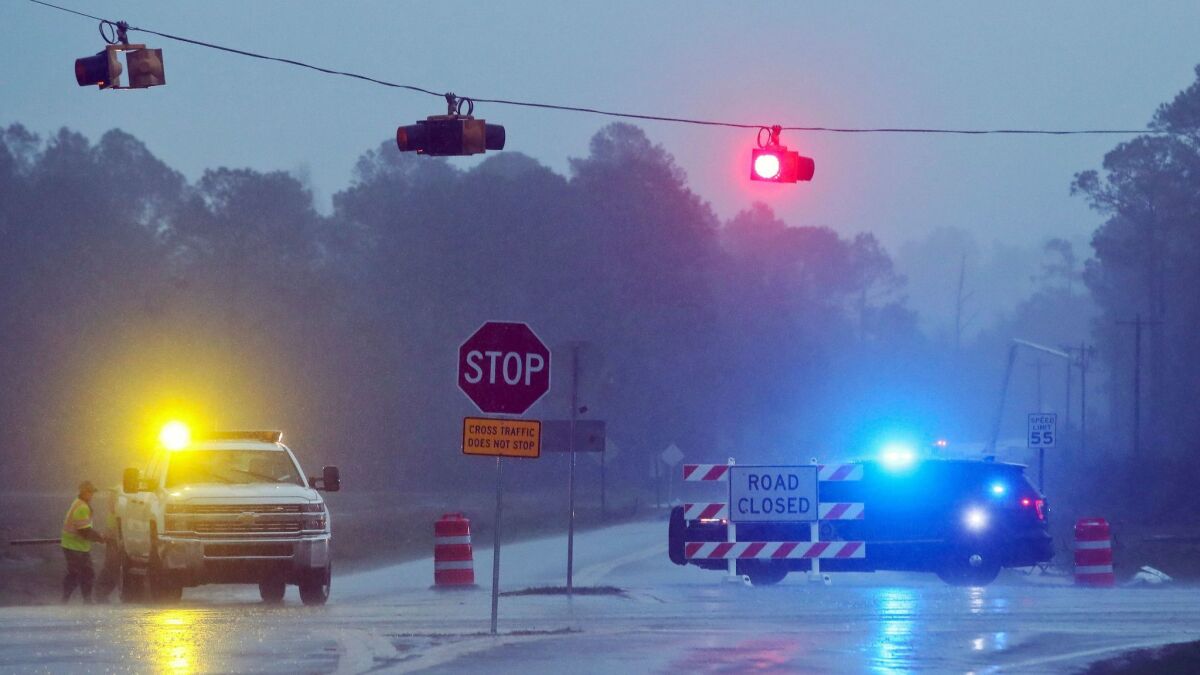 Authorities in Brooks County, Ga., block Highway 122 on Sunday as power line workers repair a downed pole.