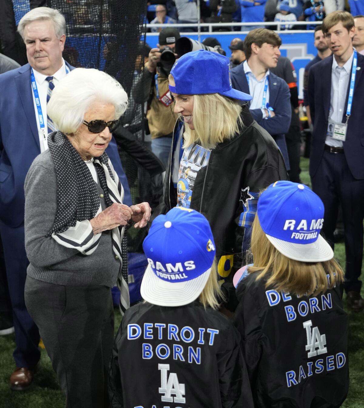 Kelly Stafford and two kids, wearing "Detroit Born, LA Raised" shirts, talk to Martha Firestone Ford