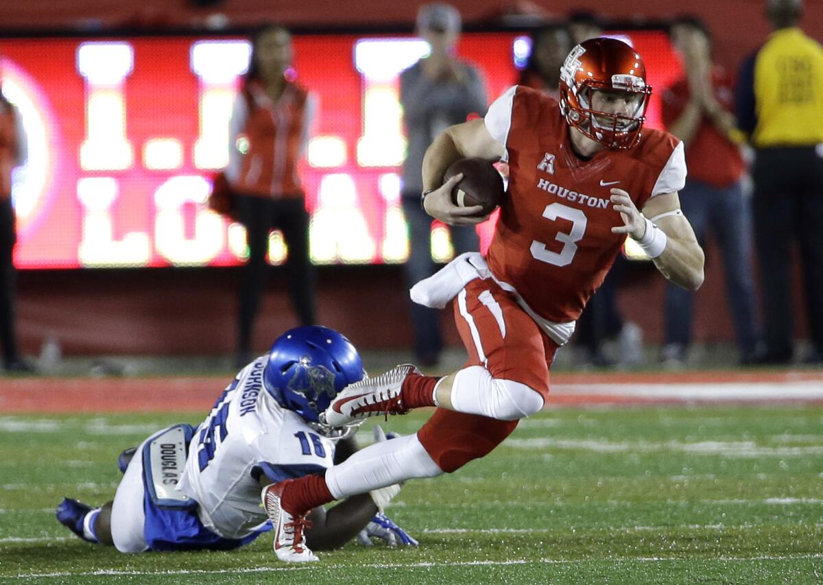 Houston quarterback Kyle Postma breaks away from Memphis defensive end Christian Johnson.