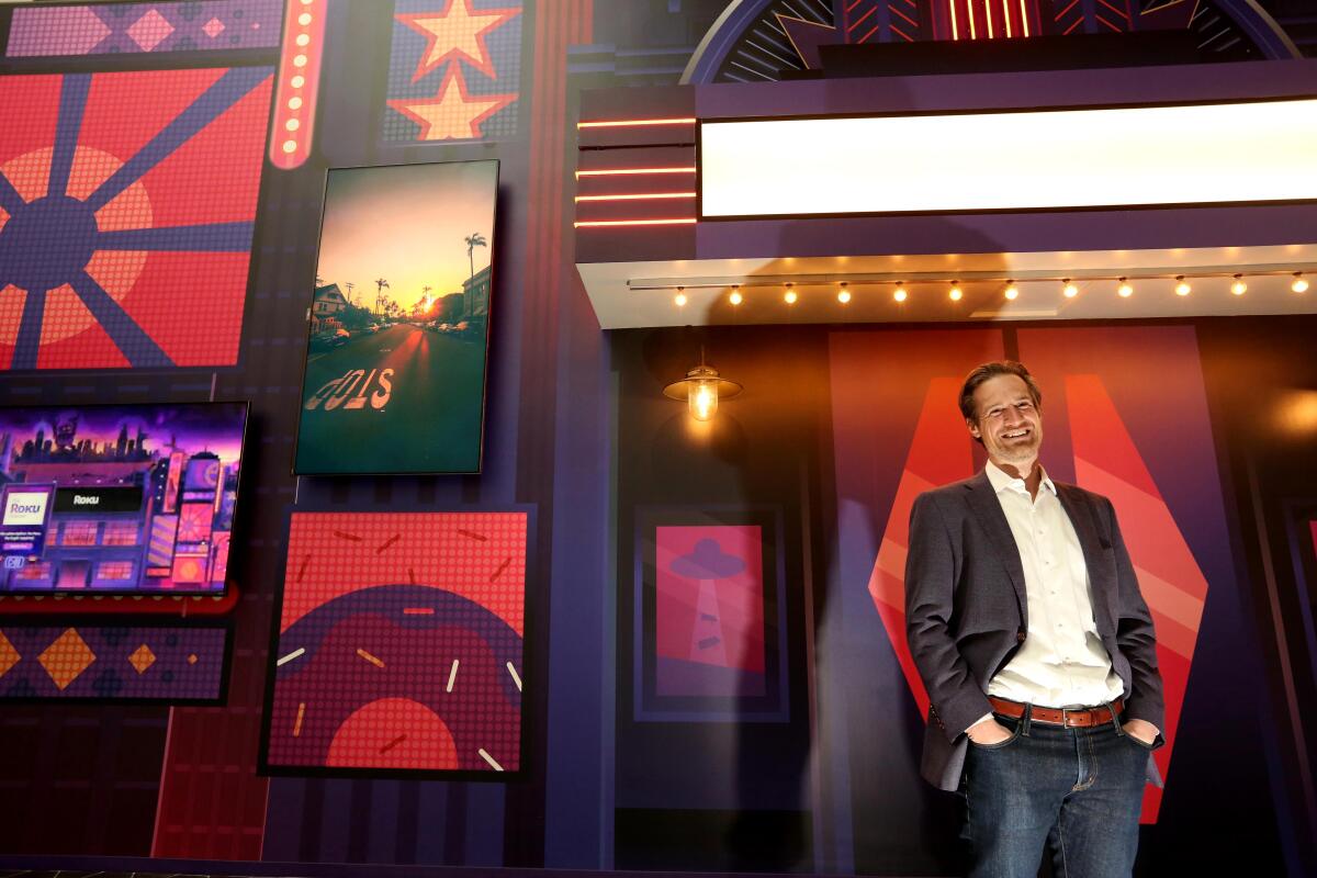 A man stands in front of a colorful mural at Roku's offices in Santa Monica.