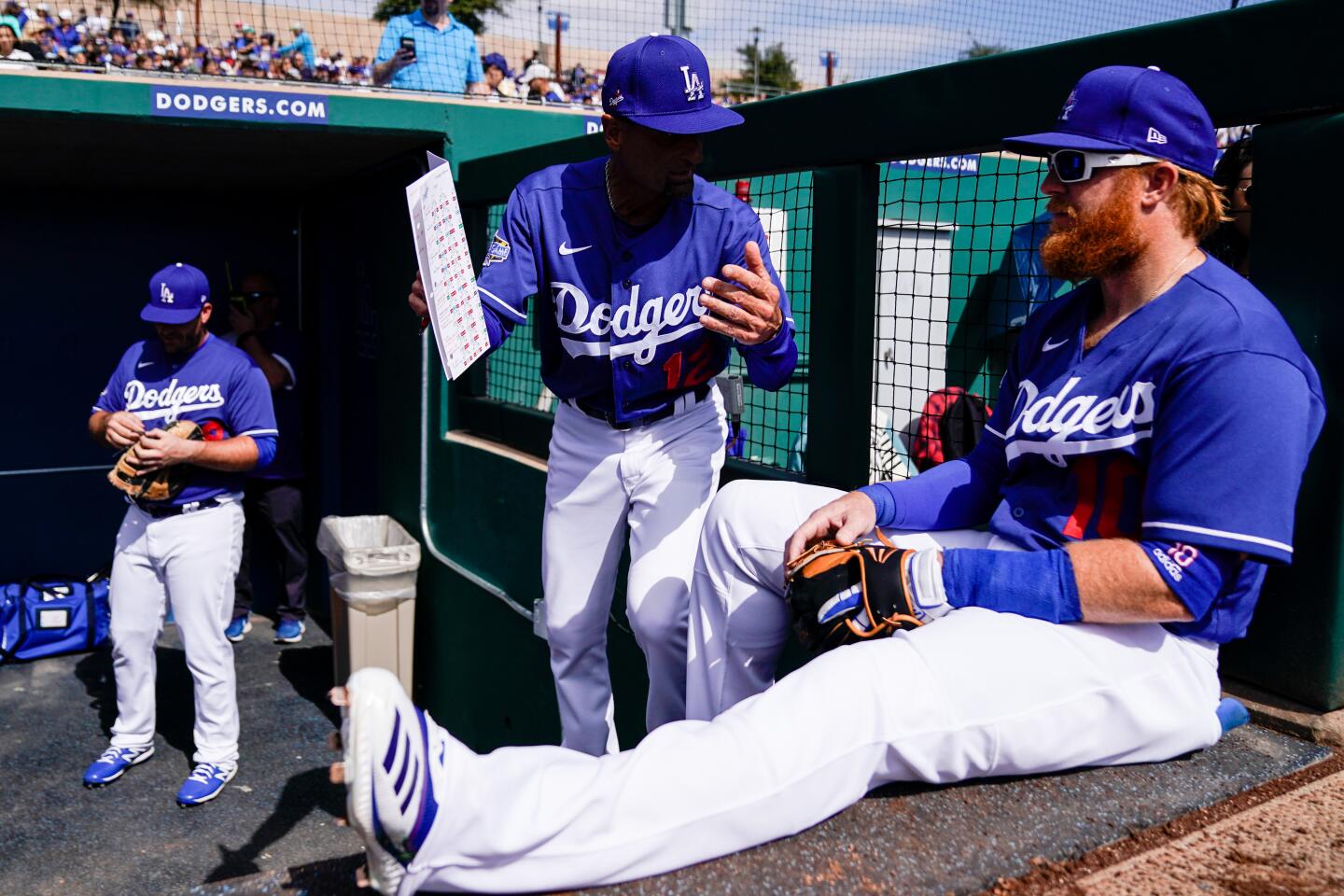 Dodgers third base coach Dino Ebel, center, speaks with third baseman Justin Turner before the start of a spring training exhibition game against the Chicago Cubs at Camelback Ranch on Feb. 23, 2020.