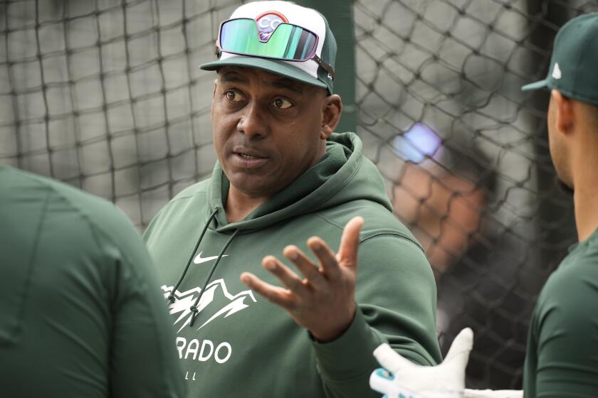 FILE - Colorado Rockies hitting coach Hensley Meulens chats with players as they warm up before a baseball game against the Philadelphia Phillies Saturday, May 13, 2023, in Denver. Federal aviation official said Friday, April 19, 2024, that they are investigating a video that appears to show Meulens sitting in the cockpit of a United Airlines charter flight while it was en route from Denver to Toronto on April 10. Unauthorized persons are not allowed onto aircraft flight decks under federal regulations. (AP Photo/David Zalubowski, File)