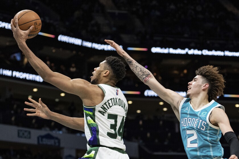 Milwaukee Bucks forward Giannis Antetokounmpo (34) drives to the basket past Charlotte Hornets guard LaMelo Ball (2) during the first half of an NBA basketball game in Charlotte, N.C., Monday, Jan. 10, 2022. (AP Photo/Jacob Kupferman)