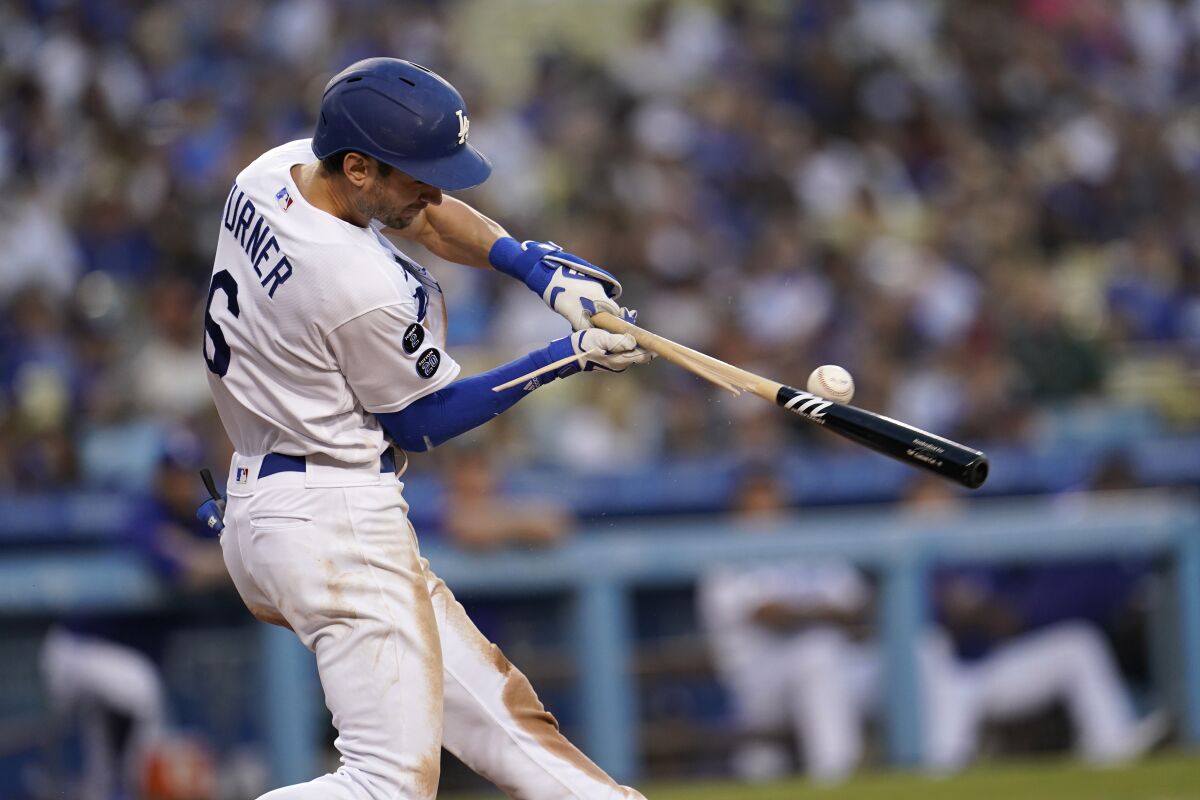 Los Angeles Dodgers' Trea Turner breaks his bat as he singles during the third inning of a game.
