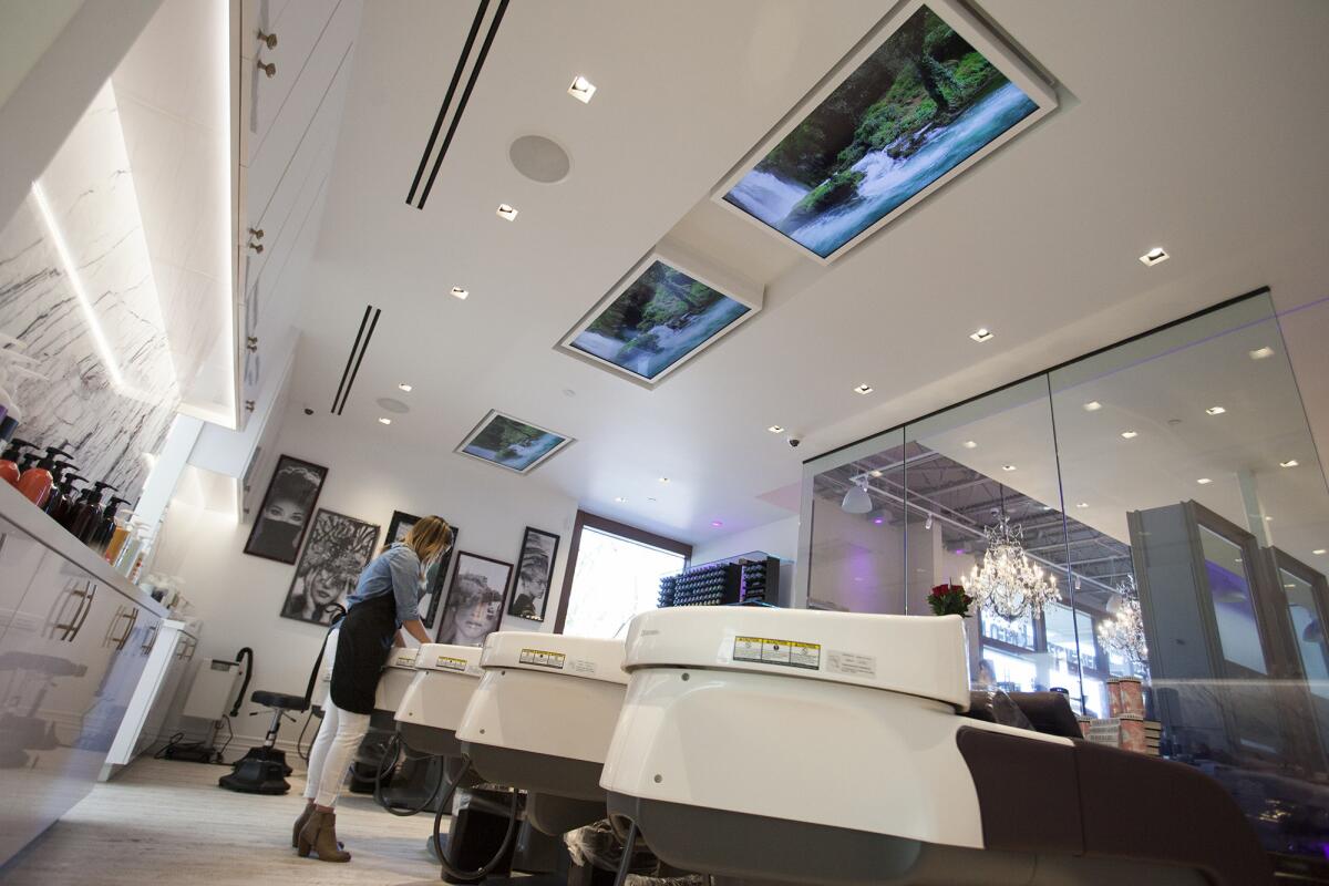 Three 50-inch flat-screen TVs mounted in the ceiling entertain clients while they get their hair washed and rinsed at Lavender Salon in Newport Beach.